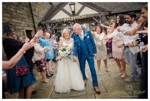 newlyweds walk through guests confetti