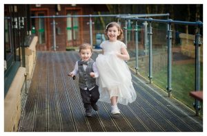 page boy and flower girl siblings running