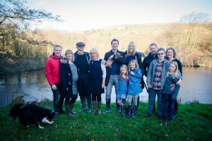 extended family group standing outside by lake
