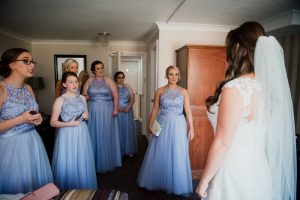 bridesmaids enter the room where the bride is getting ready