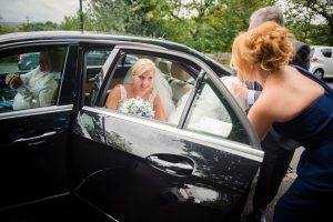 bride exits the car at the church