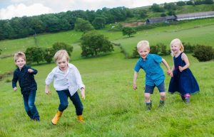 children running towards camera in field