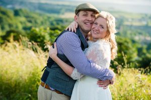 newlyweds cuddle overlooking valley