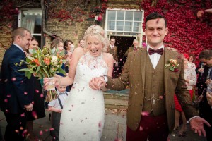 bride and groom covered in confetti laughing