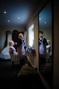 bride reflected in mirror with makeup artist