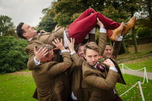 groom is lifted in the air by groomsmen