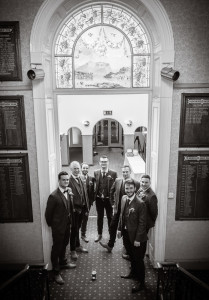 groomsmen gather around pint black and white