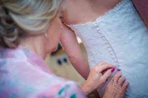 mum helps bride into dress