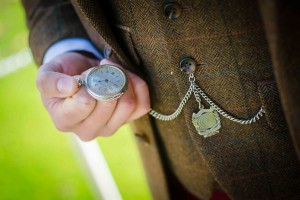 groom checks time on his pocket watch
