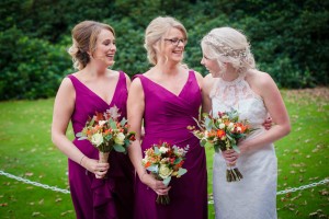 bride and sisters who are bridesmaids laughing