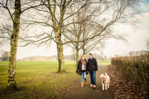 couple and dog walk in park