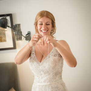 bride putting on necklace