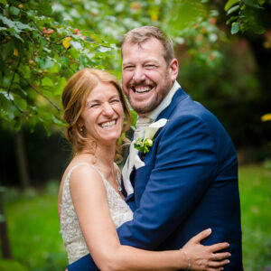 newlyweds laughing and facing the camera