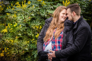 large bush with yellow leaves, couple embrace