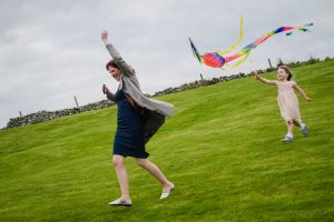 guests flying a kite running with kite