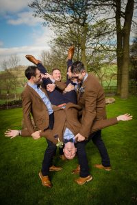 groom captured upside down held by groomsmen