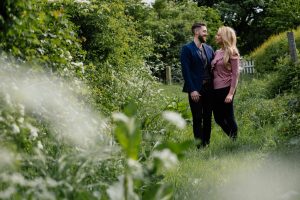 focus on couple walking on overgrown path