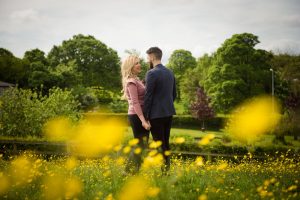 couple face each other in buttercup field