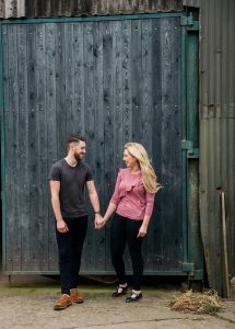 outside the barn holding hands