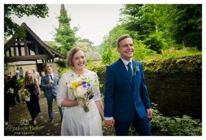 church in background as couple walk to reception