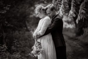 Black and white of couple standing in trees