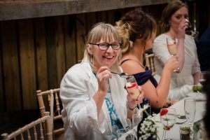 mother of the bride smiles at camera eating dessert