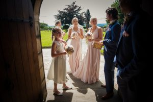 bridesmaids and groomsmen laughing in door to church