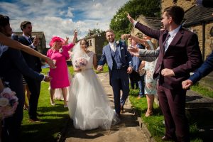 guests throw confetti at the happy couple