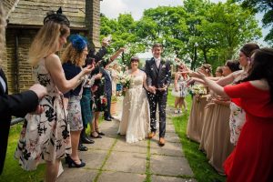 guests throw confetti outside the church