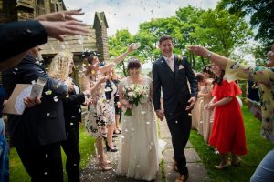 guests throw confetti outside the church