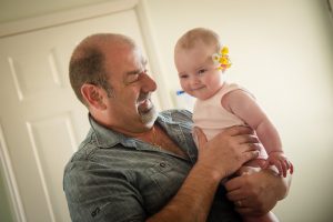 Father of the bride laughs with baby