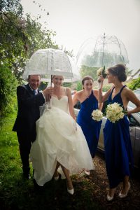 bride with umbrella arrives at church