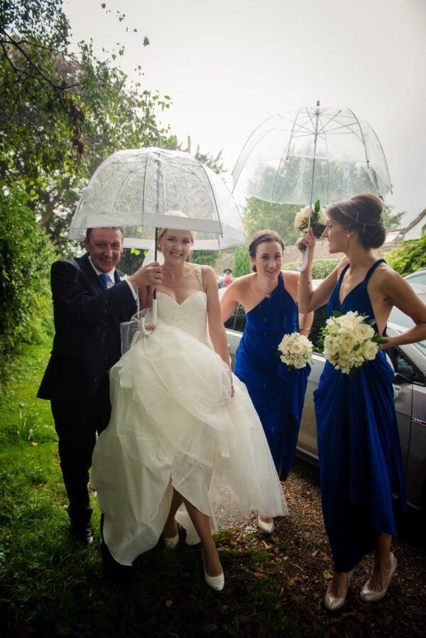 bride with umbrella arrives at church