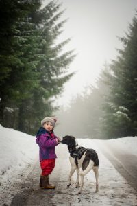 girl and dog in the snowy lane