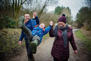 mum and dad swing little boy