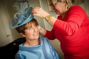 mother of the bride having hat adjusted