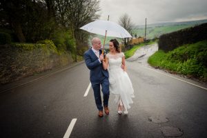 bride and groom captured walking up the road