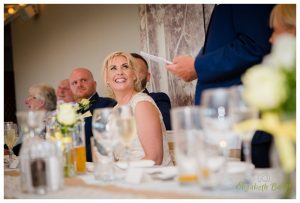 the bride listens to her father give a speech