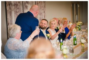 best man gives a speech with the groom looking on