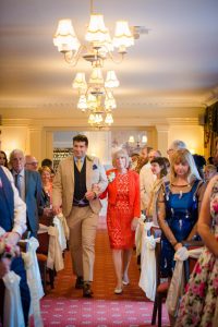 groom and mum walk down to the ceremony