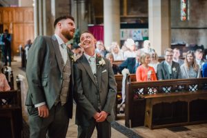 groom and best man chat at the top of the aisle