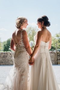Two brides looking at each other having just married at Tithe Barn