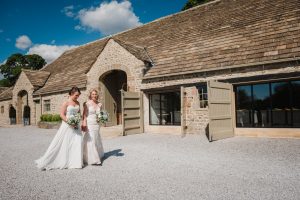 the brides take a walk outside the Tithe Barn