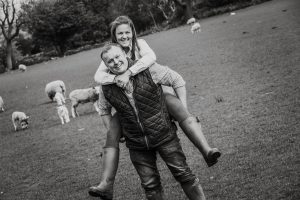 couple piggy back in a field with long grass