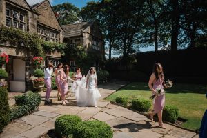 bride and bridesmaids walking to ceremony at Holdsworth House Halifax wedding