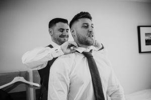 black and white shot of groom getting ready
