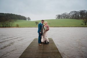 newlyweds by the lake at Coniston hOtel landscape shot