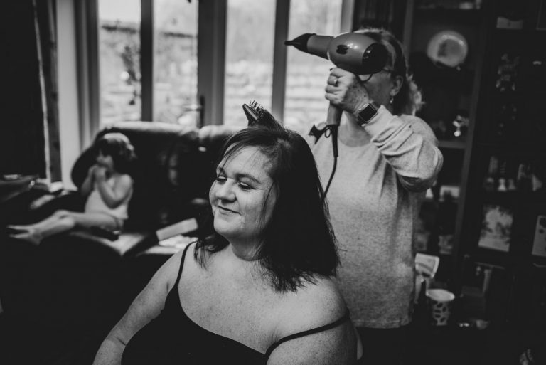 black and white hairdresser finishes brides hair