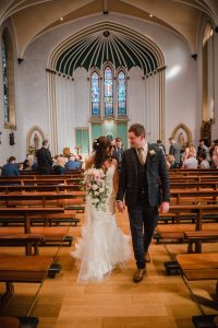 portrait of the newlyweds coming down the aisle