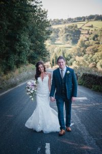 bride and groom portraits walking towards camera country landscape